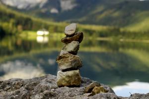 Gestapelte Steine am Ufer eines Bergsees