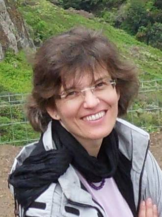 Ursula Scheid im Freien, vor einer grünen Hanglandschaft